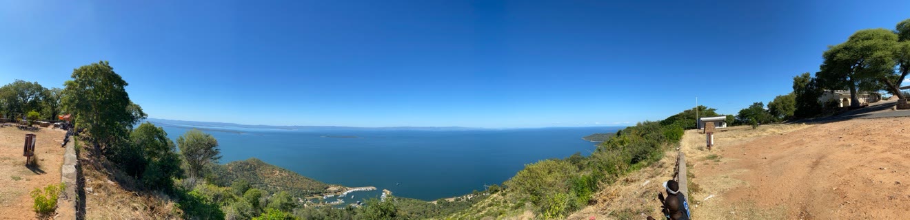 Lake Kariba stretching to the horizon under a clear sky, seen from the heights above Kariba town with the marina far below